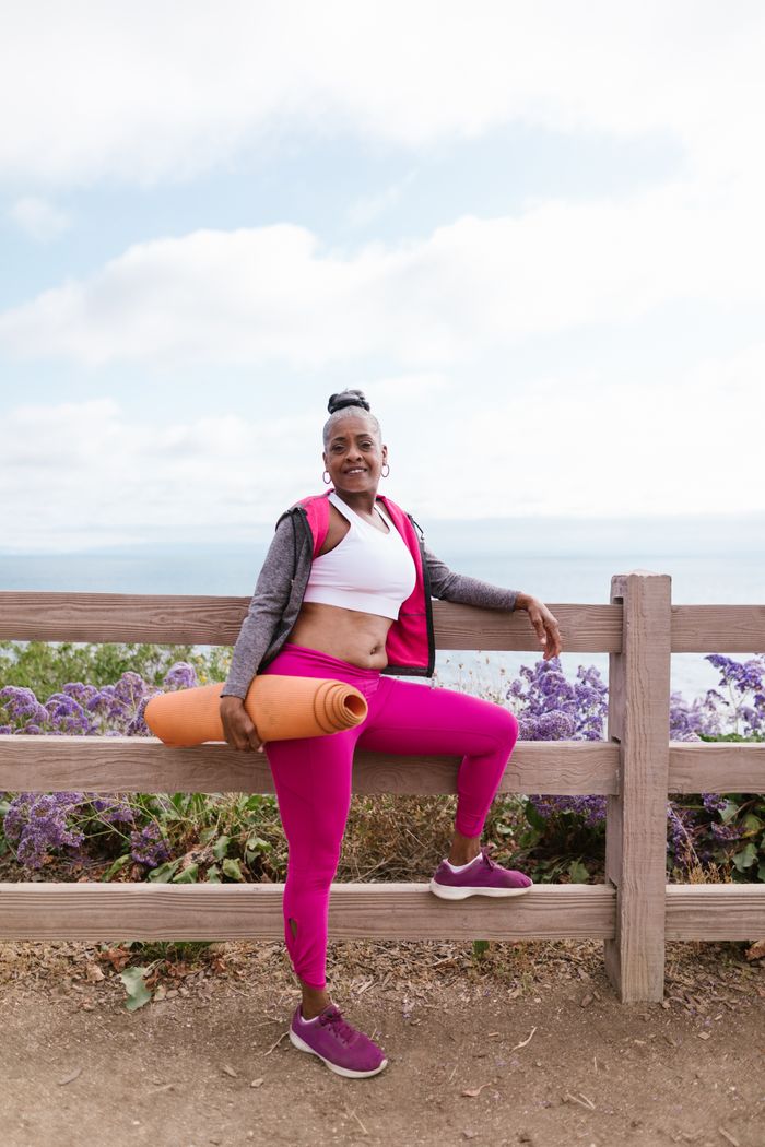 The Art of Drawing Readers In: Your attractive post title goes here Senior woman with yoga mat posing by the seaside, promoting healthy and active lifestyle.